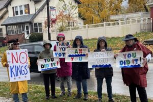 protestors in the rain holding signs that say "You did it."