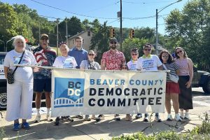 smiling volunteers ready to march in a parade behind the BCDC banner